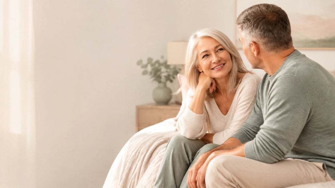 Midlife couple having a warm, honest conversation in a softly lit bedroom